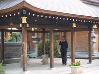  Business man wandering around inside the shrine with his mobile phone...